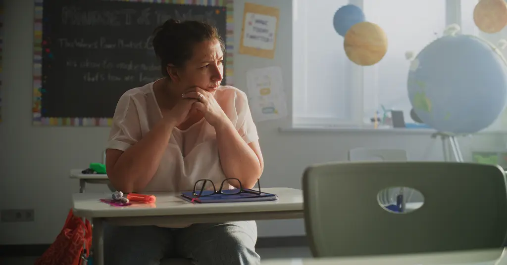 Frau sitzt nachdenklich am Schreibtisch im Kinderzimmer – Berufsorientierung für Mütter zwischen Familie und beruflicher Neuorientierung